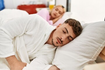 Young caucasian couple sleeping lying on the bed at home.