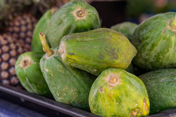 Piles of huge ripe tropical papaya ready for eating at a fruit and vegetable market stall in Southeast Asia