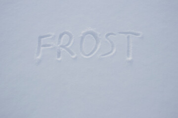 inscription of frost on the snow. children wrote frost in the snow. cold season.