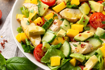 Tasty Chicken mango salad with avocado, cucumber, cherry tomatoes. Healthy food