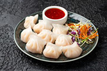 Traditional Asian Prawn or shrimp dumplings hakau, ha kauw or har gow. Served with cabbage, carrot salad and soy and sweet chilli sauce