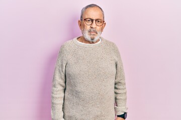 Handsome senior man with beard wearing casual sweater and glasses looking sleepy and tired, exhausted for fatigue and hangover, lazy eyes in the morning.
