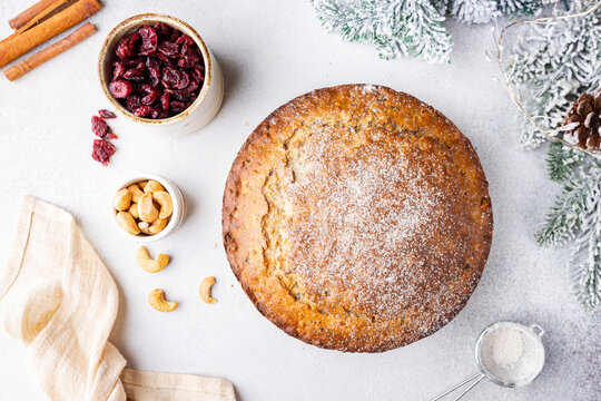 Traditional Christmas cake pudding with fruits and nuts with Christmas decorations, light background, top view