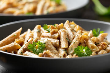 Whole Wheat Penne pasta with gorgonzola cheese sauce, spinach and walnut. Healthy food.