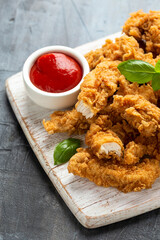 Fried Chicken strips with ketchup on white wooden board. Fast Food