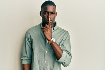 Young african american man wearing casual clothes asking to be quiet with finger on lips. silence and secret concept.