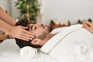 Man relaxed reciving head massage at beauty center.