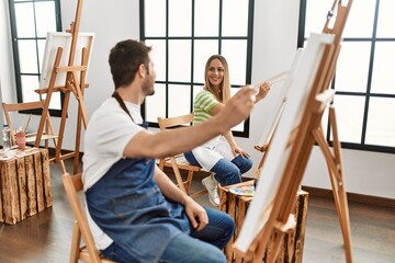 Two hispanic students smiling happy painting at art studio