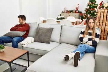 Obraz premium Young hispanic couple with problems sitting on the sofa in silence at home.