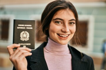 Young beautiful businesswoman smiling happy holding italy passport at the city.