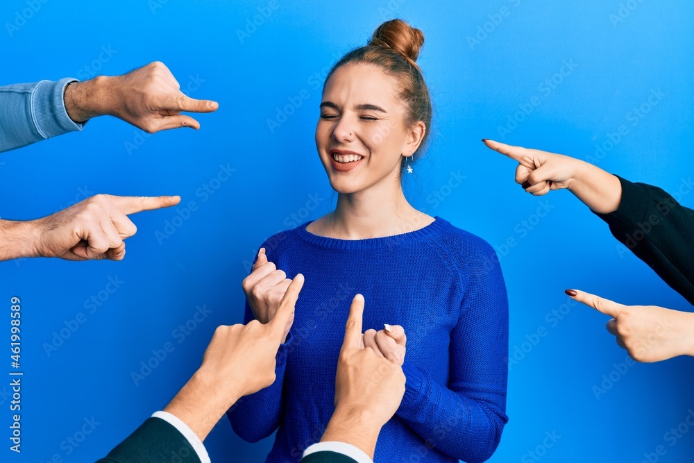 Poster young blonde woman with pointing fingers around her celebrating surprised and amazed for success wit