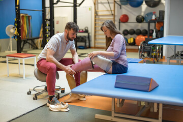 Physiotherapist helping young woman with prosthetic legs
