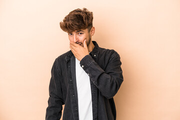 Fototapeta premium Young arab man isolated on beige background covering mouth with hands looking worried.