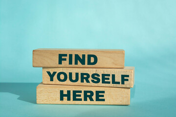 Find Yourself Here Text on Wooden Blocks on blue Background