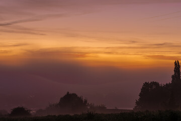 Early morning fog during a colourful sunrise in Maastricht, the Netherlands. These kind of mornings are often seen in the Autumn season