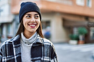 Young hispanic woman smiling happy standing at the city.