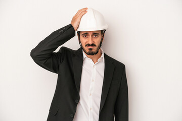 Young architect man wearing a construction helmet isolated on white background being shocked, she has remembered important meeting.