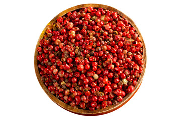 red peppercorn seeds in wooden plate