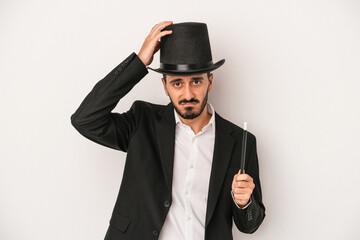 Young magician man holding wand isolated on white background being shocked, she has remembered important meeting.