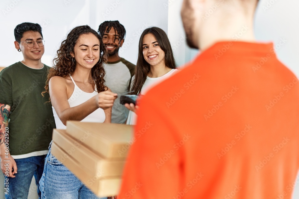 Wall mural Group of people holding take away pizzas from deliveryman at home.