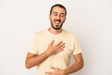 Young caucasian man isolated on white background laughs happily and has fun keeping hands on...
