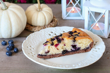 Traditional autumn blueberry seasonal cake and table decoration with white baby boo pumpkins.