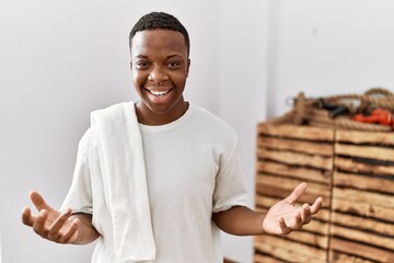 Young african man wearing sportswear and towel celebrating mad and crazy for success with arms...
