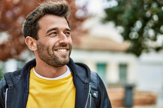 Handsome hispanic man with beard smiling happy outdoors
