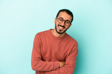 Young caucasian man isolated on blue background laughing and having fun.