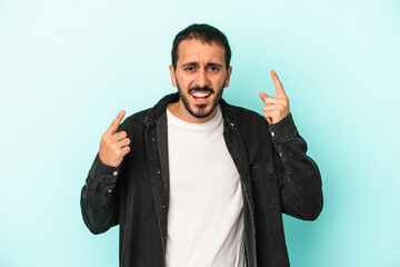 Fototapeta premium Young caucasian man isolated on blue background showing a disappointment gesture with forefinger.
