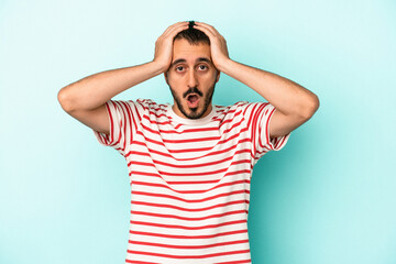 Fototapeta premium Young caucasian man isolated on blue background being shocked, she has remembered important meeting.