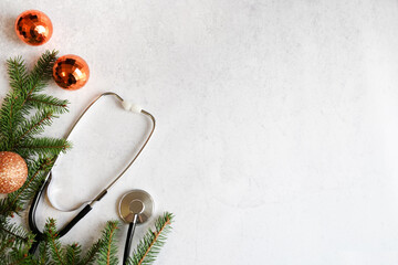 Celebrating Christmas in the healthcare industry. Top view of flat lay. Stethoscope with ornaments...