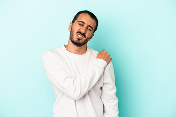 Obraz premium Young caucasian man isolated on blue background having a shoulder pain.