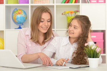 mother and daughter using laptop