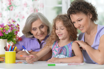 Mother, grandmother and girl  drawing together