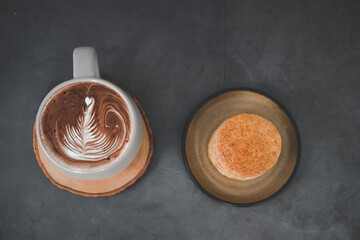 Hot mocha coffee with latte art and scone. Top view