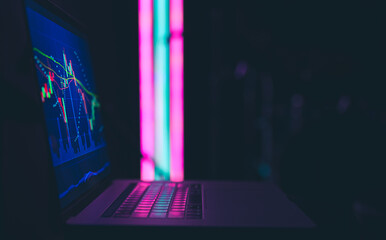 Stock market graph, financial data on an electronic board on a laptop screen.