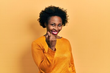 Fototapeta na wymiar Young african american woman wearing casual clothes beckoning come here gesture with hand inviting welcoming happy and smiling