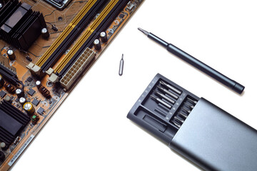 Computer motherboard and screwdriver on white background isolated