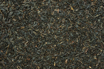 Black tea leaves top view backdrop. close-up detail background
