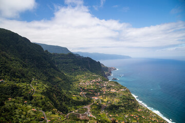 Fototapeta na wymiar Green Mountains and a Small Village by the sea seen from 