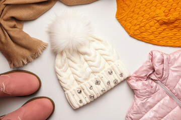 A set of warm autumn-winter clothes on a light gray background. Flat top view copy space