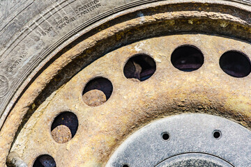 Old rusty car wheel rim closeup