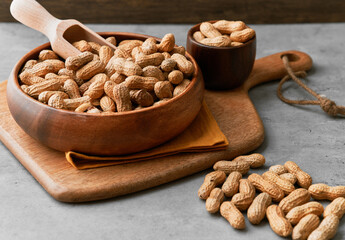 Image of wooden spoons with peanuts on a concrete surface