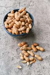 Image of bunch of peanuts in a bowl on a concrete surface