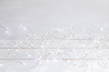Christmas decoration, christmas lights on white table, silver garland, copy space
