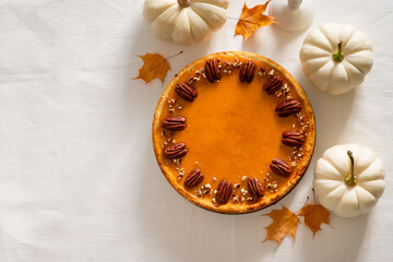 Traditional pumpkin pie on table, flat lay with pumpkins