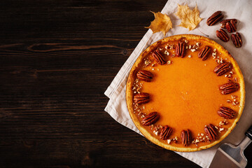 Traditional pumpkin pie on table, flat lay with pumpkins