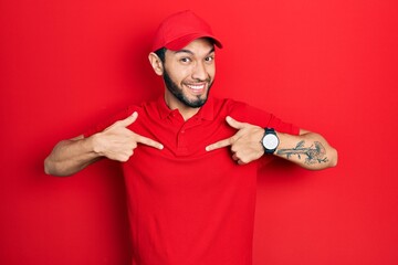 Hispanic man with beard wearing delivery uniform and cap looking confident with smile on face, pointing oneself with fingers proud and happy.