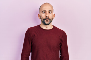 Obraz premium Young bald man wearing casual clothes making fish face with lips, crazy and comical gesture. funny expression.